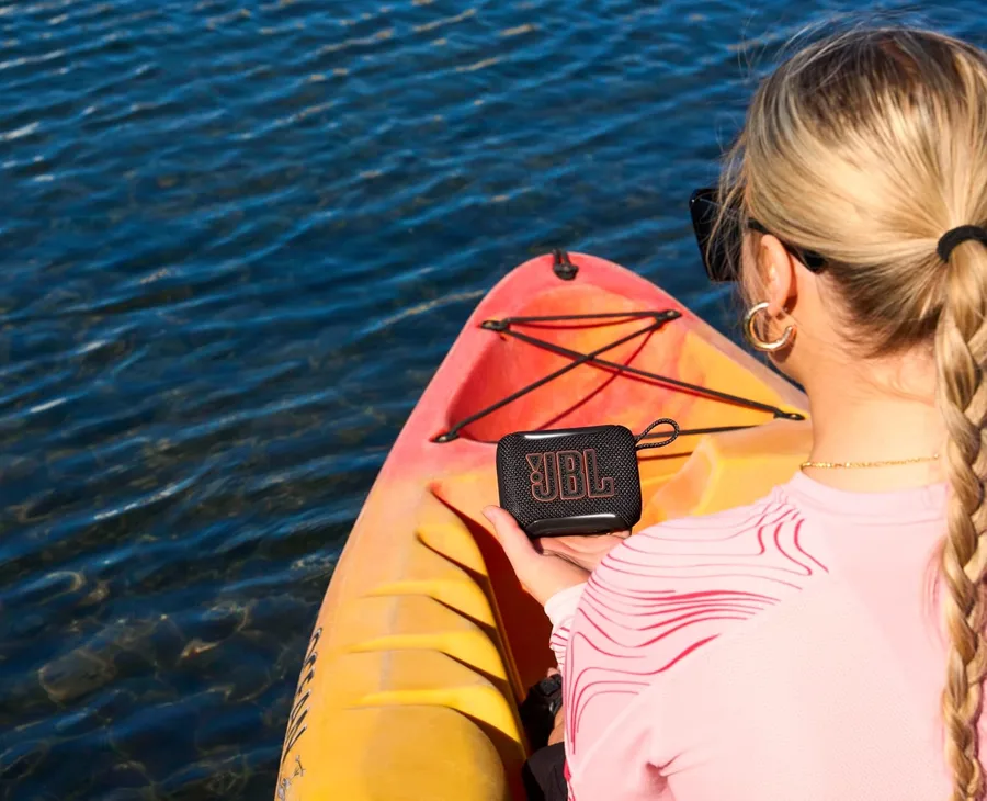 JBL Go 5 appesa allo zaino di una ragazza in kayak