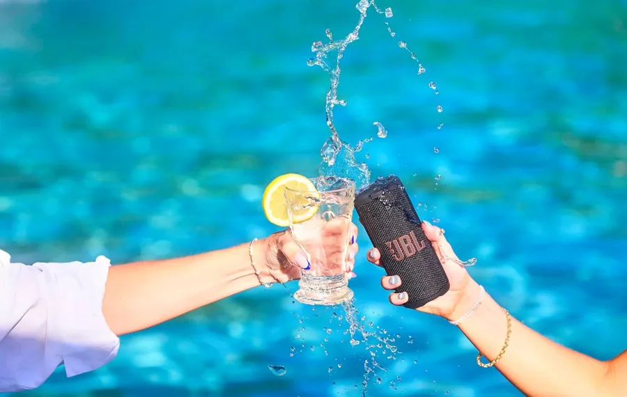 Cassa JBL Grip impermeabile tra gli spruzzi di una piscina