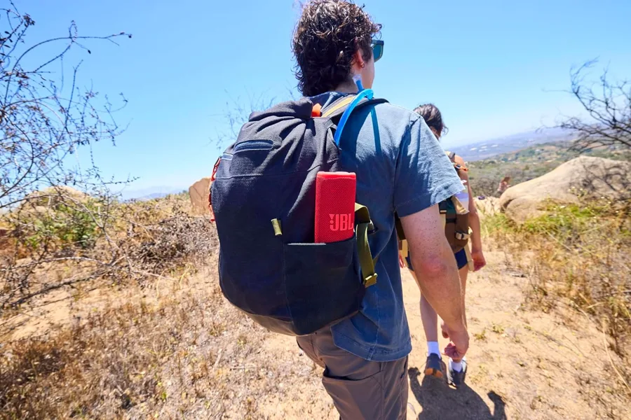 Escursionista con lo zaino e la cassa JBL Grip